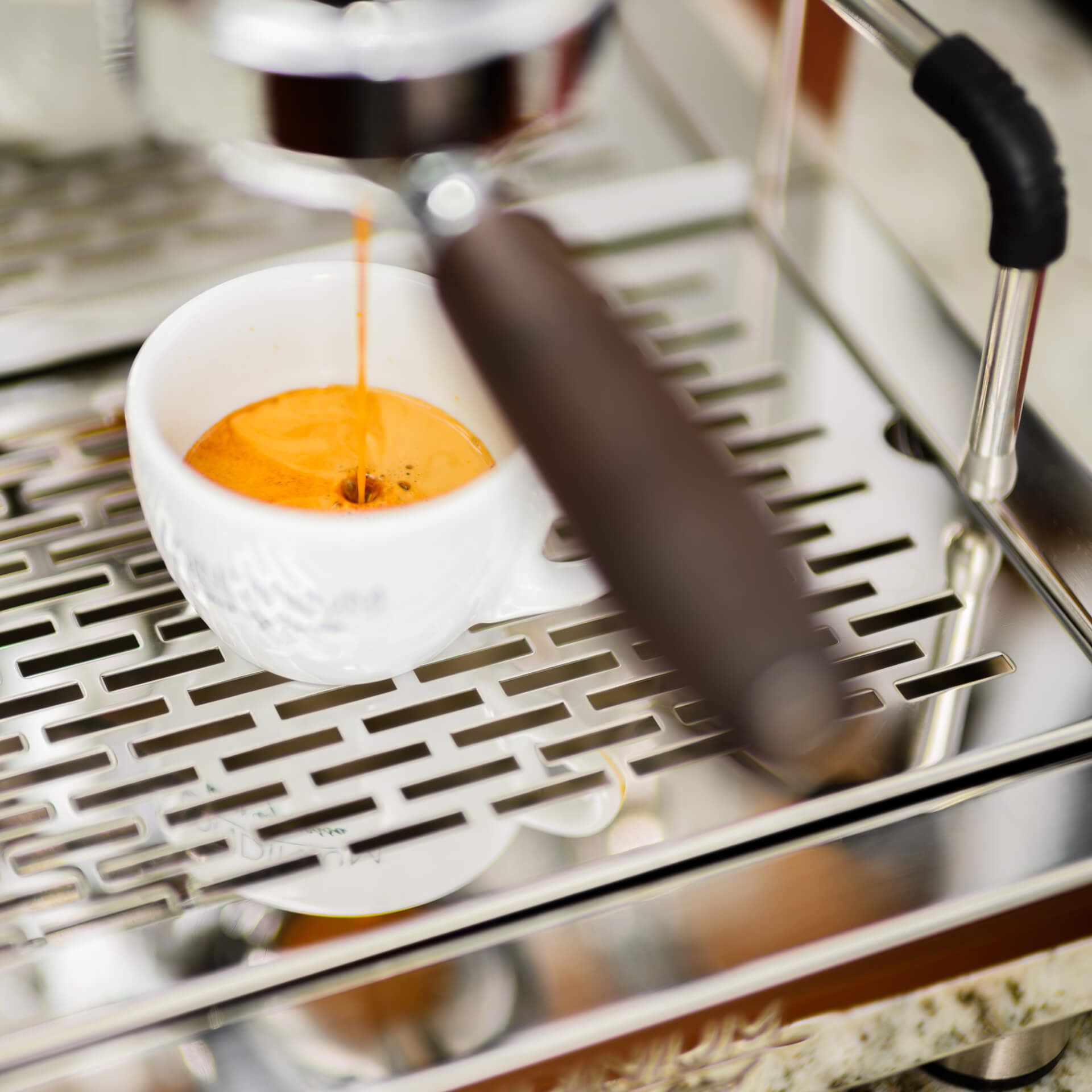 Londinium official close view of espresso extracting from the current R24 spring group into a white cup